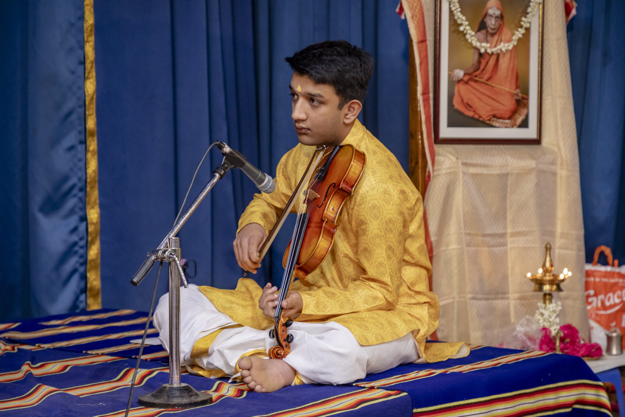 Vivek playing the violin while sat down